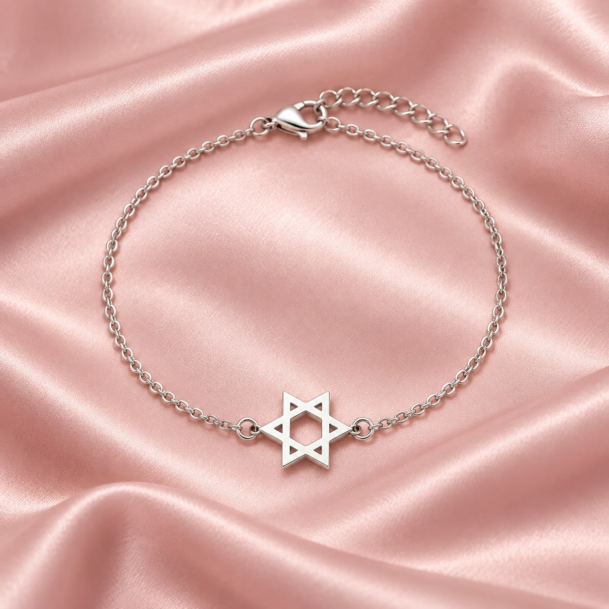 צמיד שרשרת עדין בגוון כסף עם תליון מגן דוד מחורר על רקע סאטן ורוד
